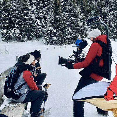 cameraman filmant deux personnes sur un banc dans la neige
